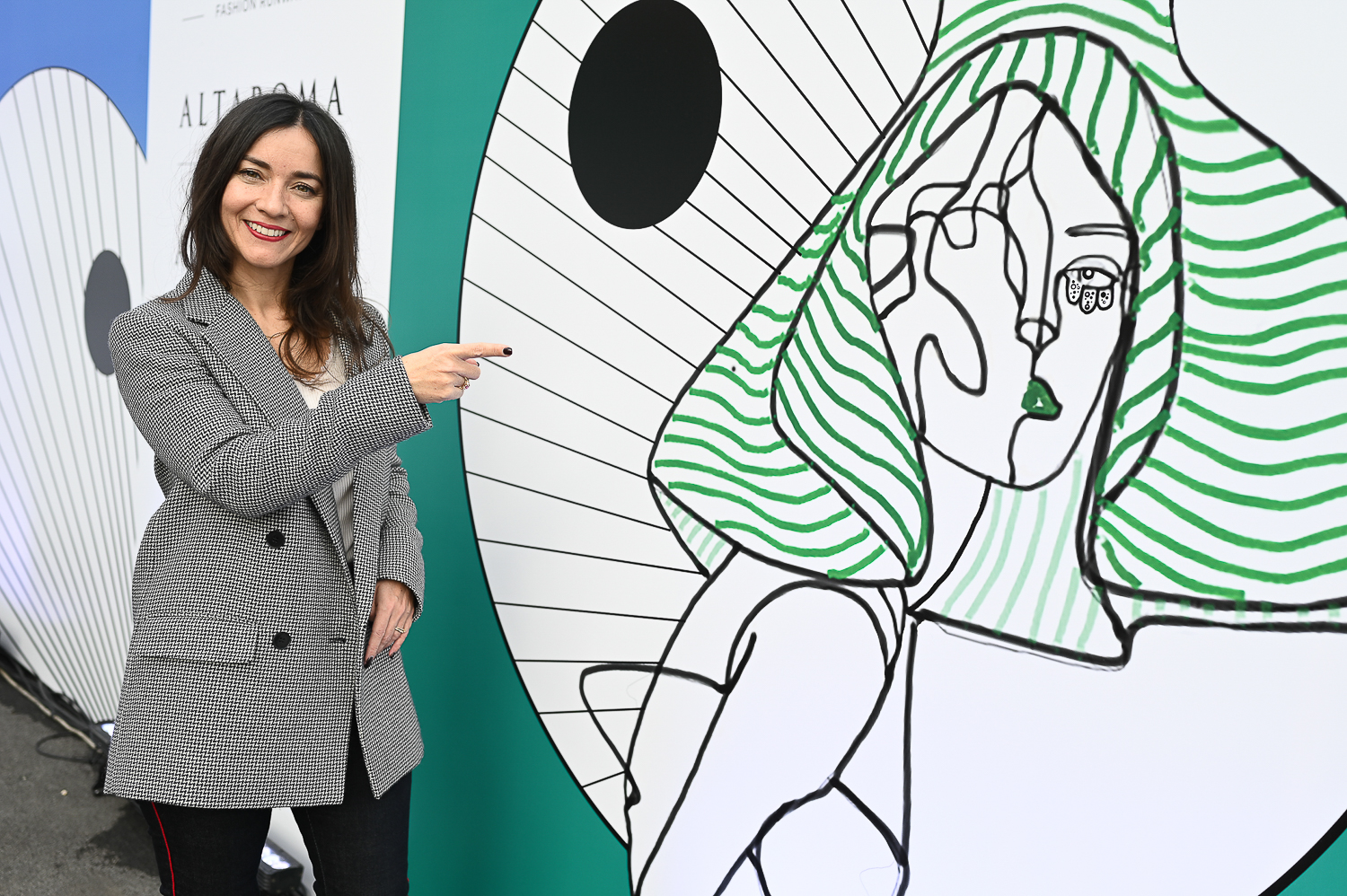 Delphine Souquet in front of the illustration by Gabriele Melodia